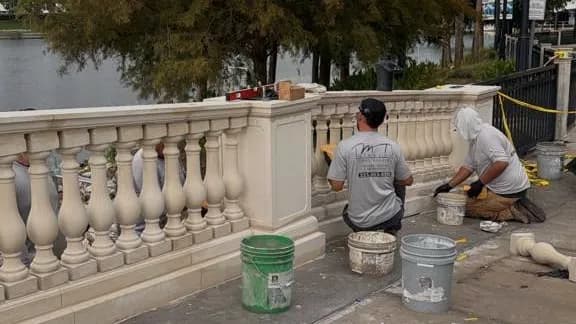 Crew restoring a masonry balustrade on a jobsite
