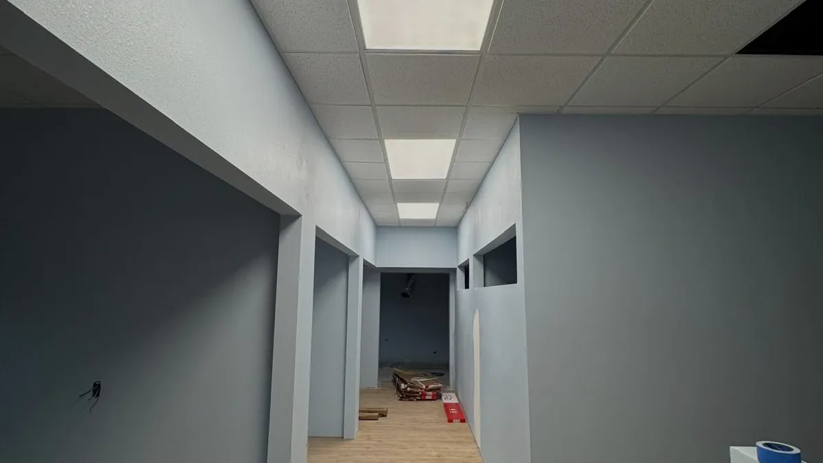 Finished drywall and ceiling grid in a commercial corridor